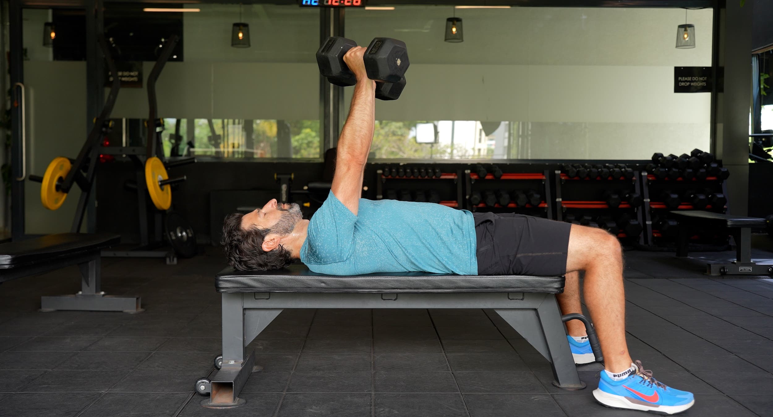 A man performs a dumbbell bench press