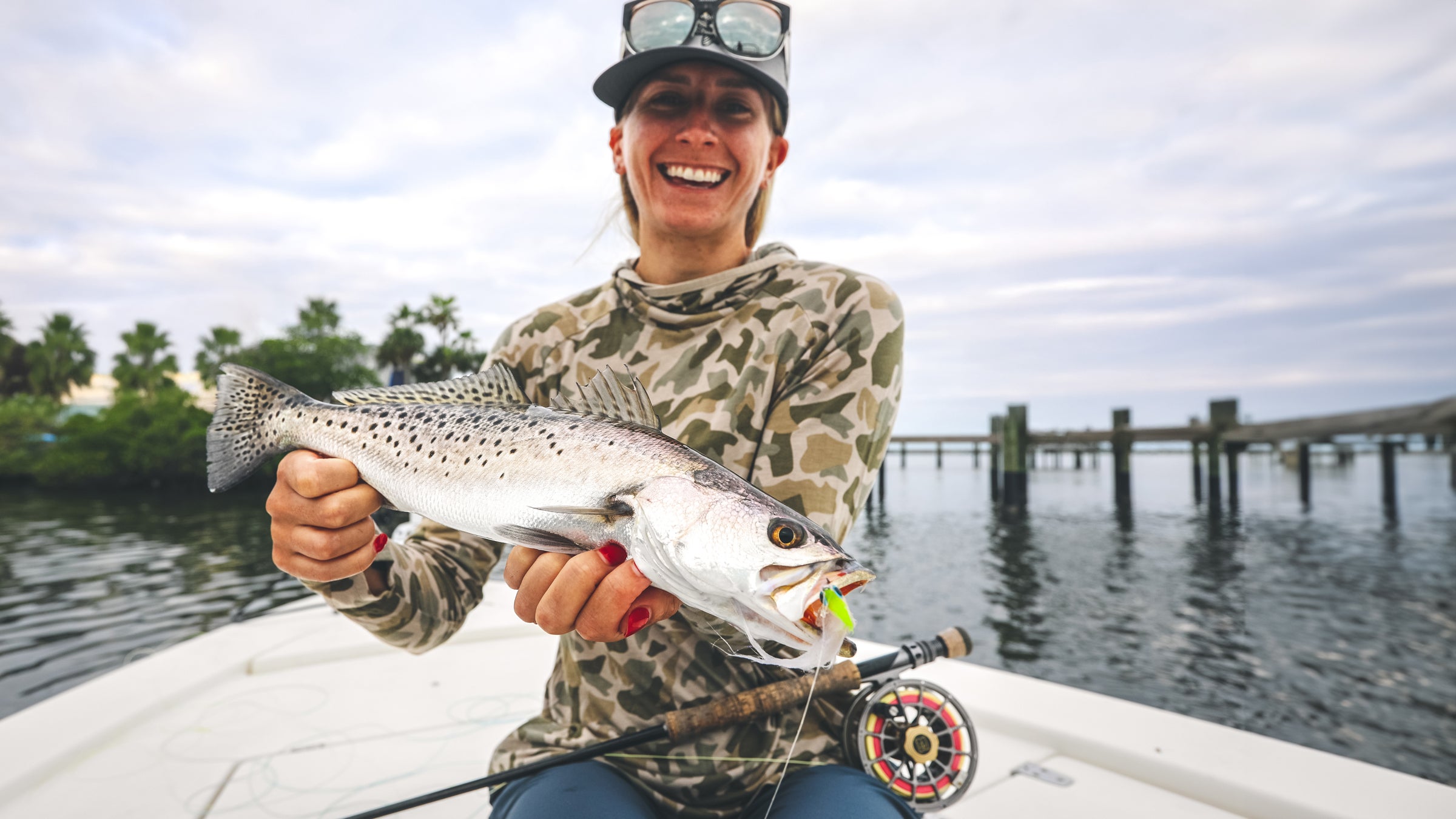 An angler displays a beautiful spotted sea trout caught on a hand-tied fly.