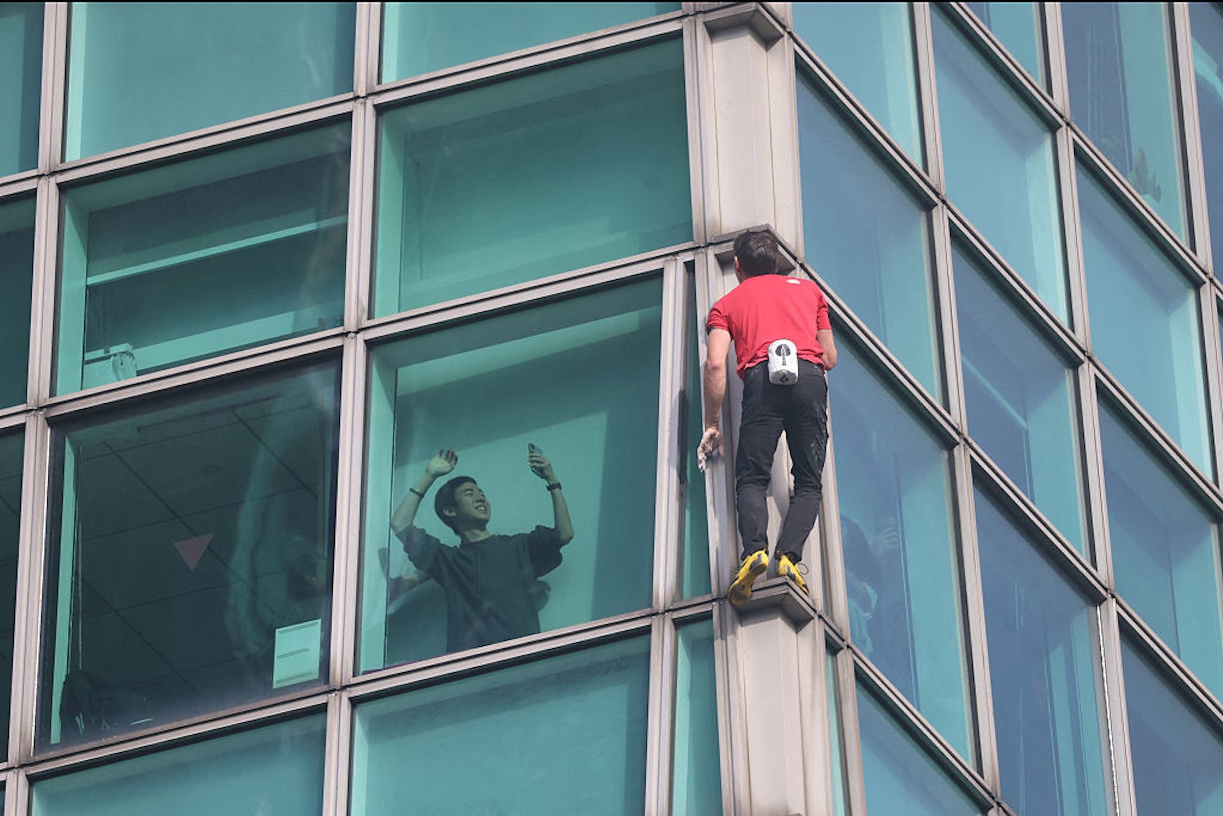 A viewer records Alex Honnold climbing the Taipei 101 building