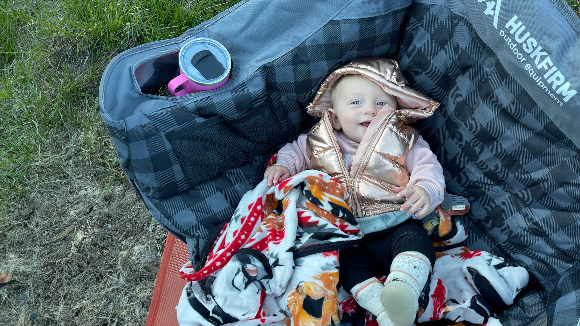 Editor Abigail Wise's daughter relaxes in a loveseat camping chair outdoors.