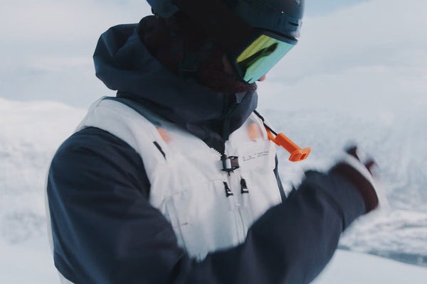 Skier with black jacket and white vest puling Safeback SBX trigger handle