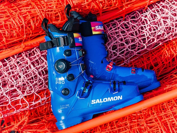 Blue Salomon S/Pro Alpha C BOA ski boots displayed on orange race netting