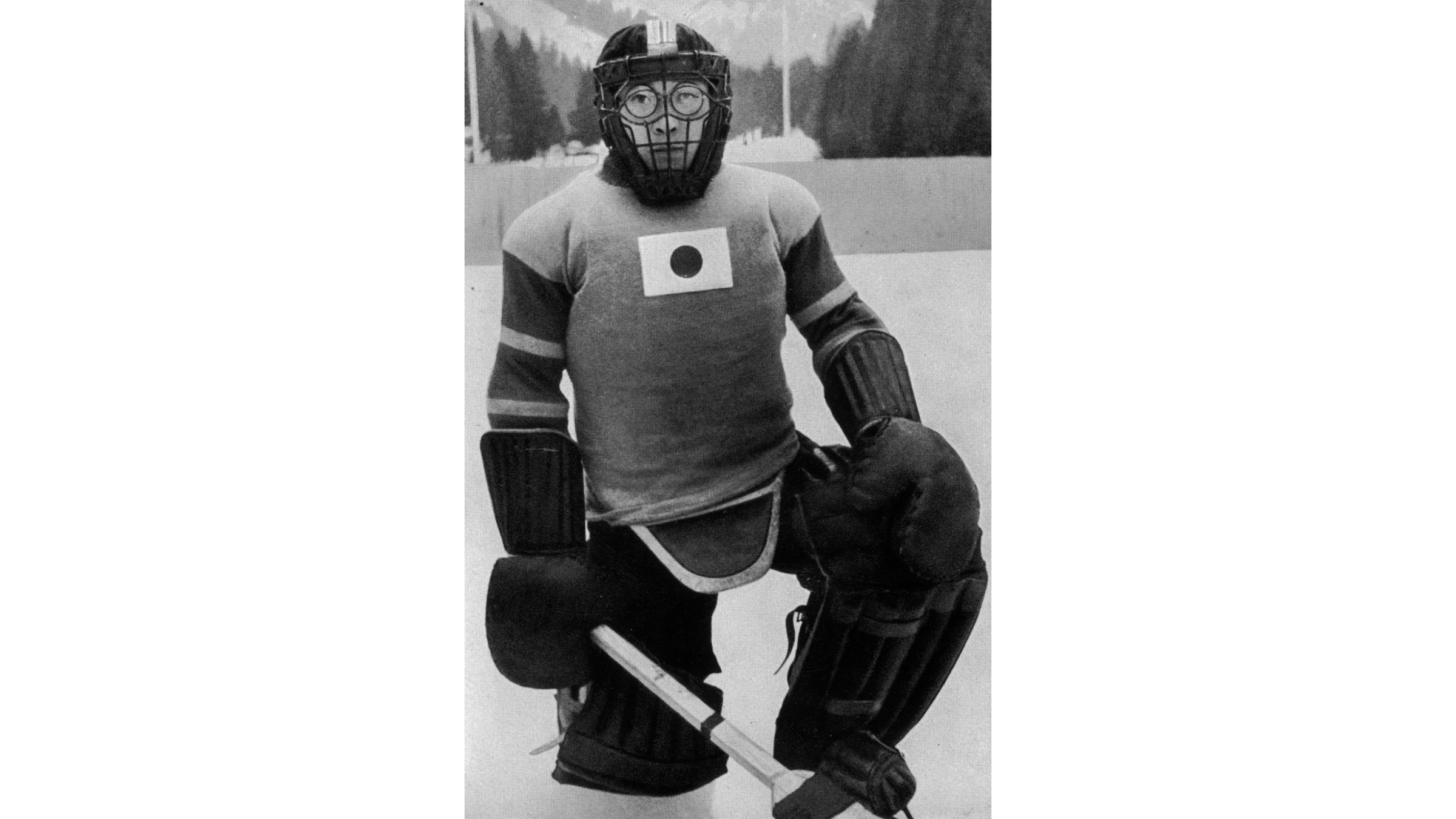 Japanese goaltender Teiji Honma poses in his Winter Olympics gear at the 1936 Garmisch-Partenkirchen Games, featuring a pioneering full wire-cage mask designed to protect his glasses.