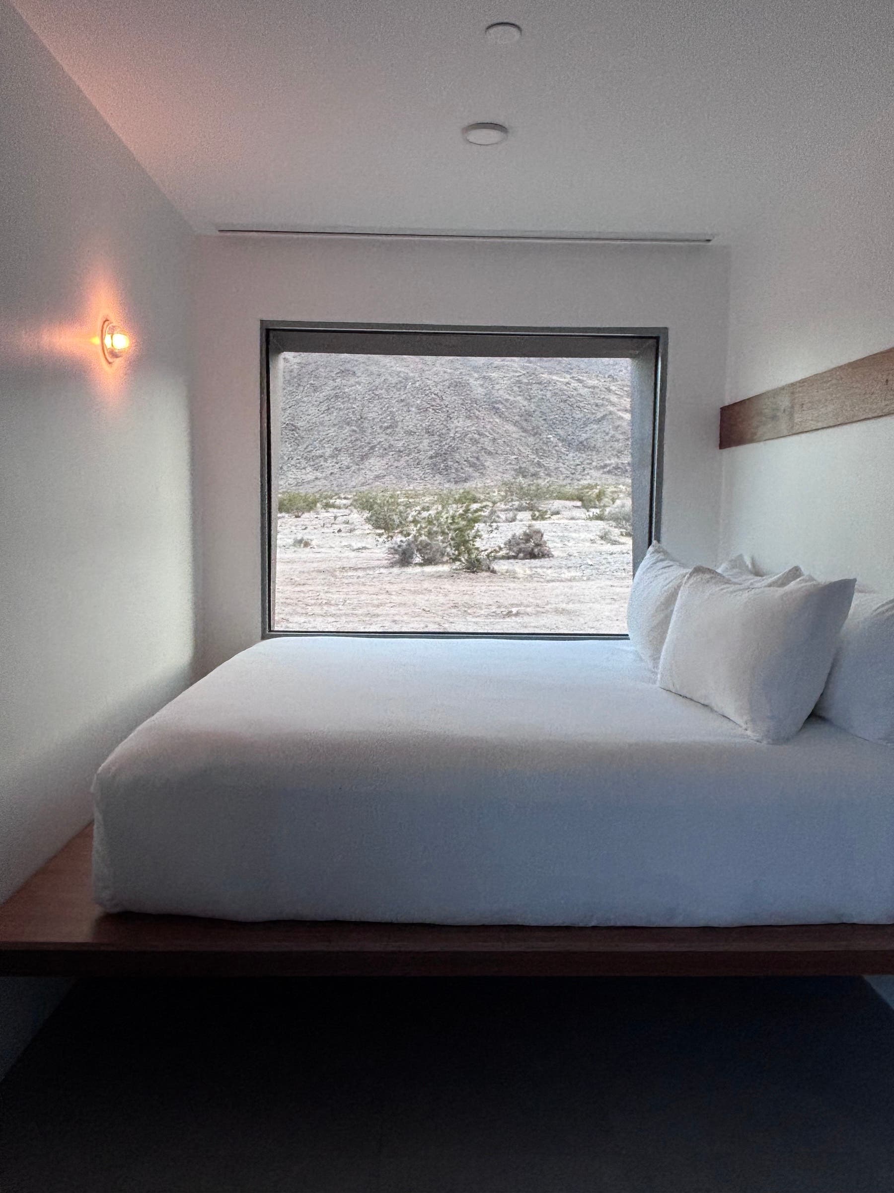 a king bed room at reset against a large window with Mojave desert views