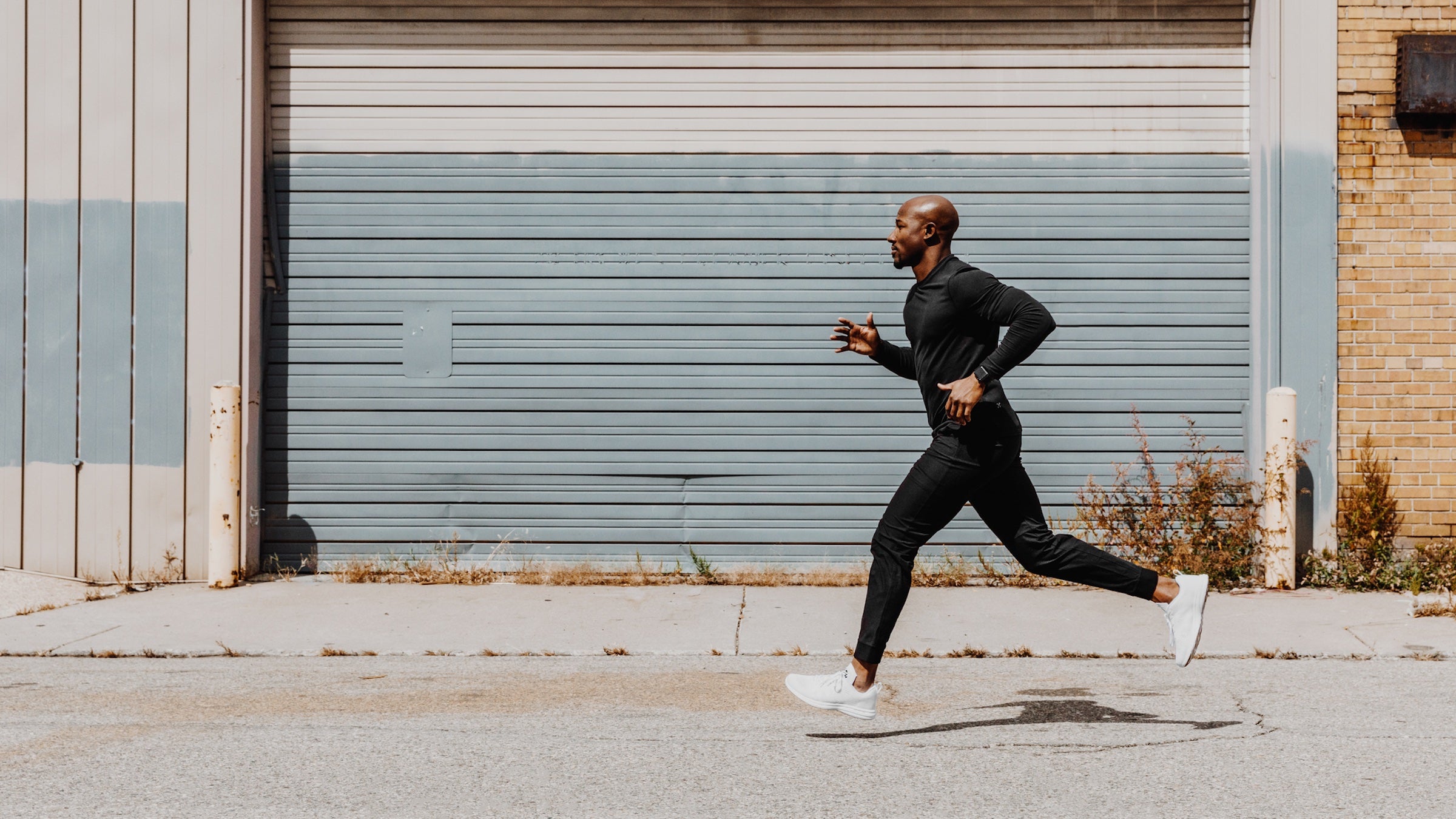 man running in black on pavement