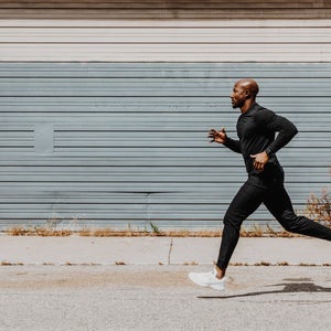 man running in black on pavement