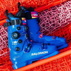 Blue Salomon S/Pro Alpha C BOA ski boots displayed on orange race netting