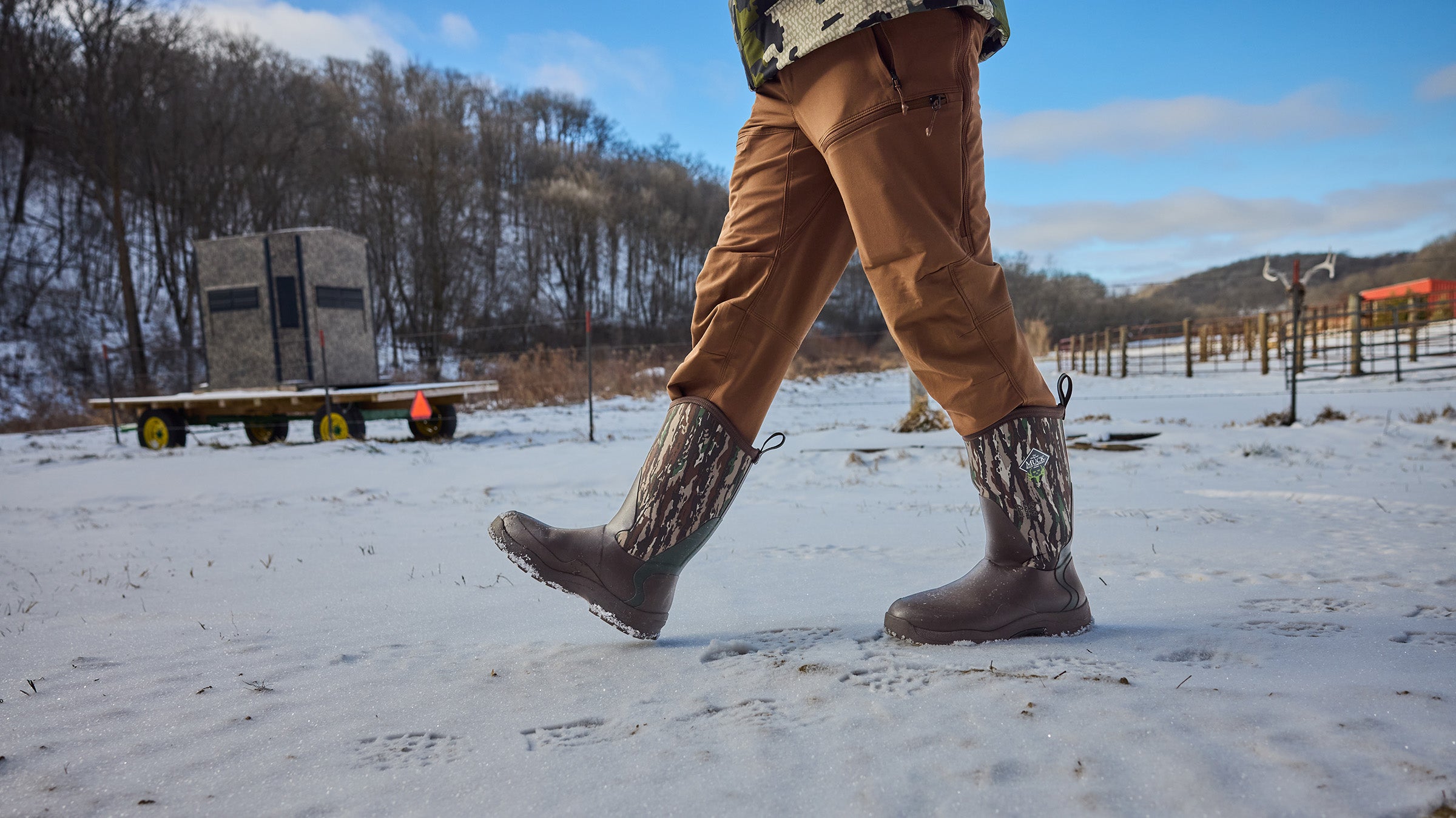 Closeup of man walking in hunting boots and khaki pants over snow