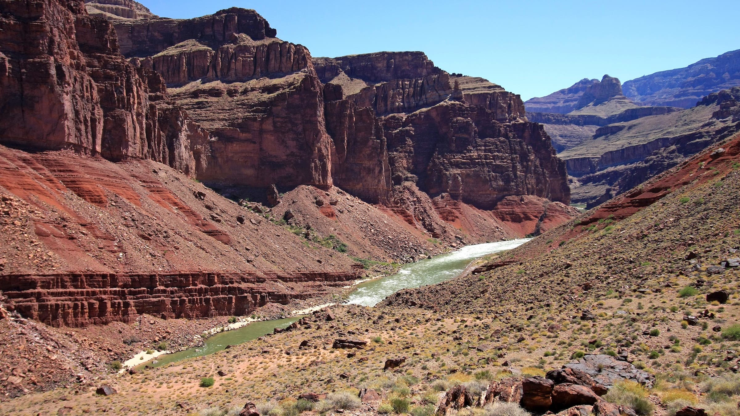 Distant hikers on Tonto Trail descending toward Hance Rapids in Grand Canyon National Park