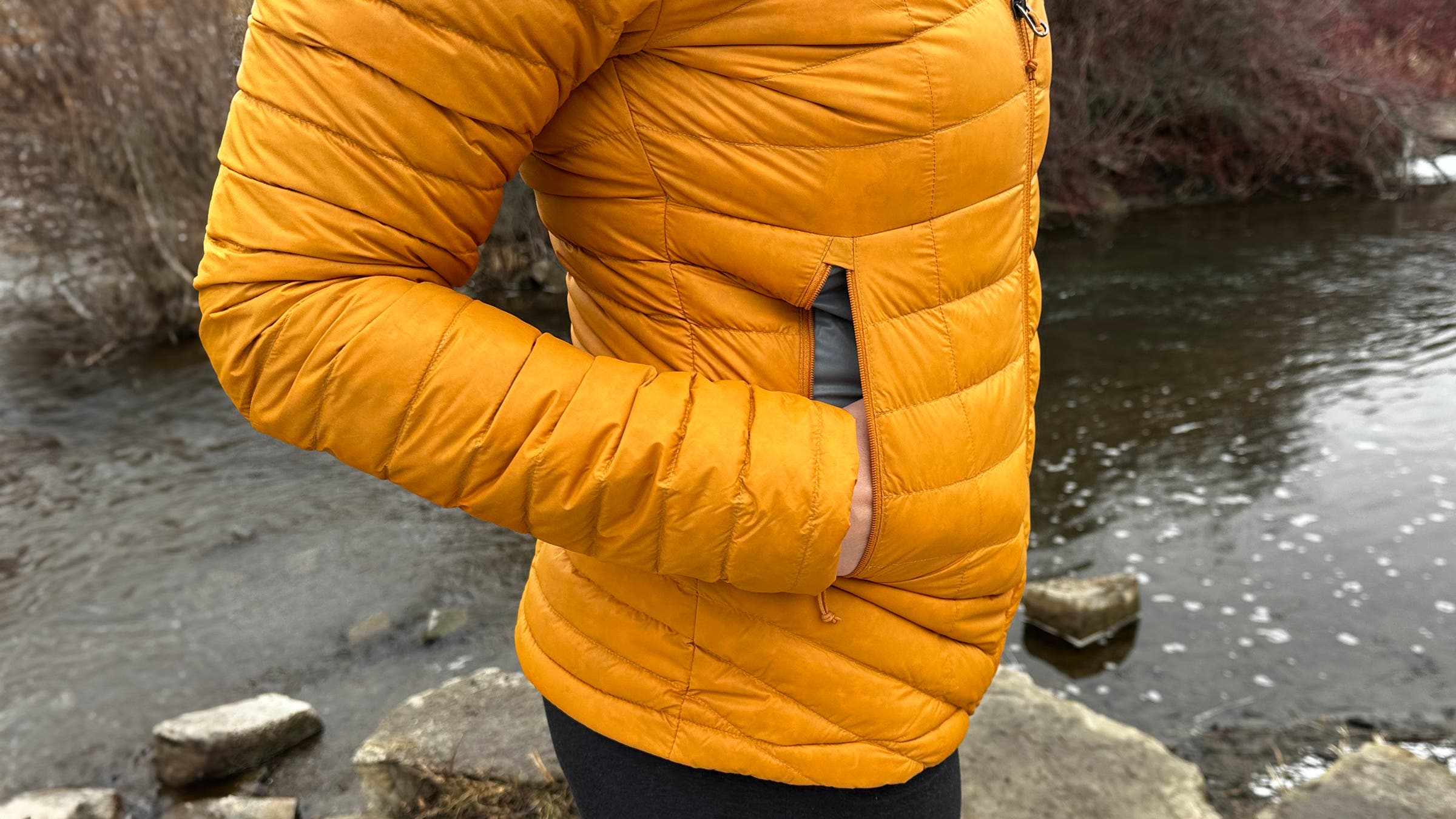 Decathlon Simond MT100 Down Puffer side pocket view on hiking trail.