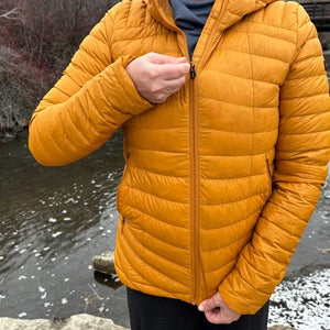 Decathlon Simond MT100 Down Puffer jacket zipping up in front of stream.