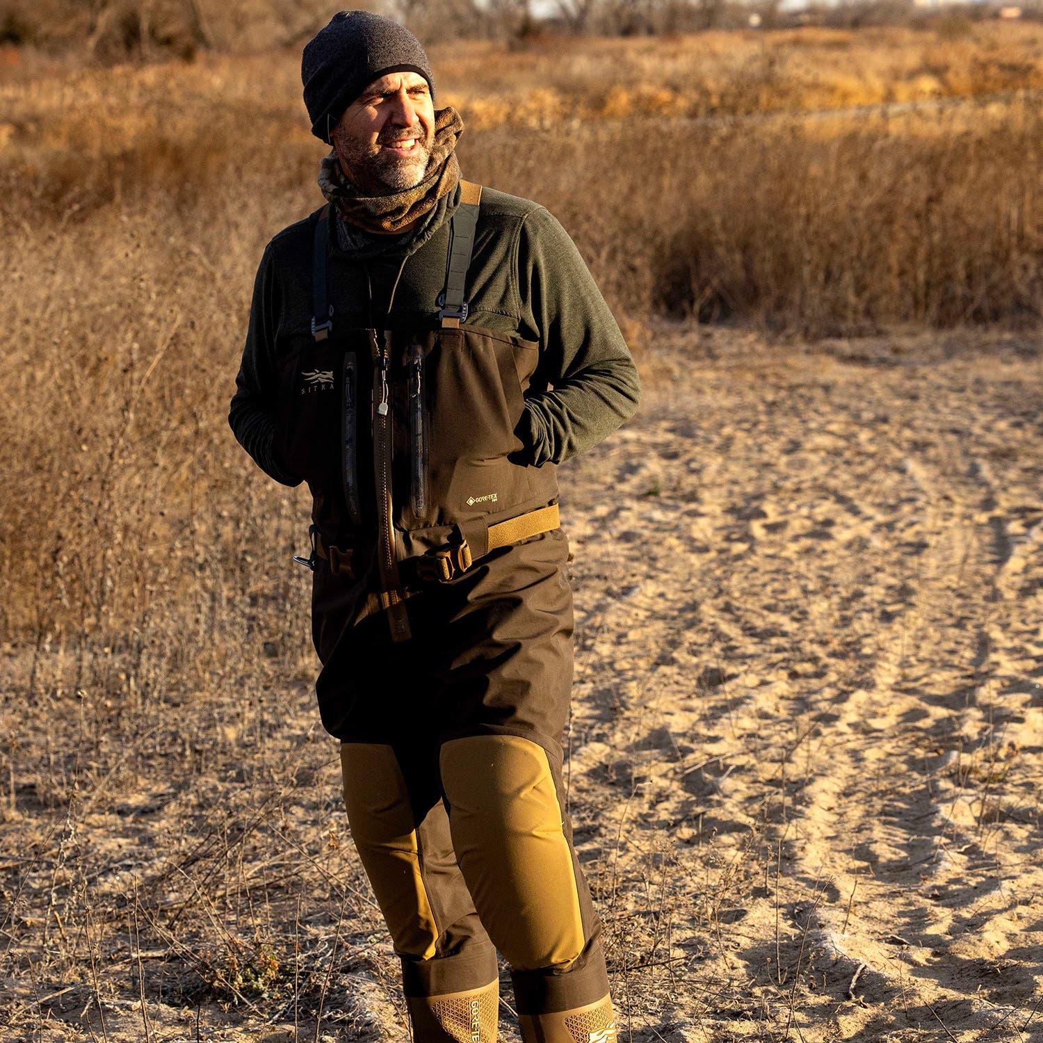 Man wearing Sitka Delta VentLite waders on sandy beach in winter