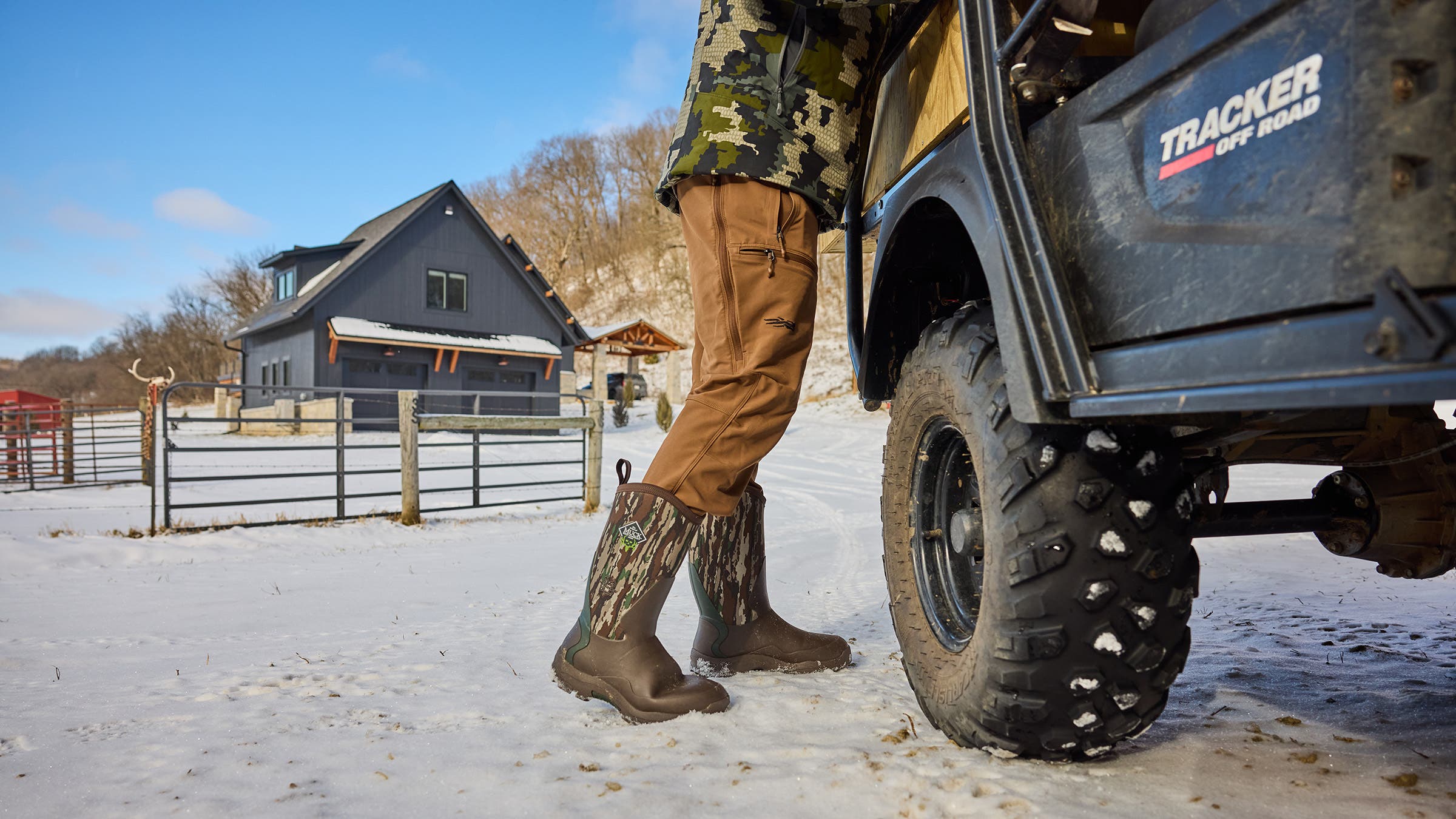 Closeup of man wearing khaki Sitka Endurance hunting pants while leaning onto truck