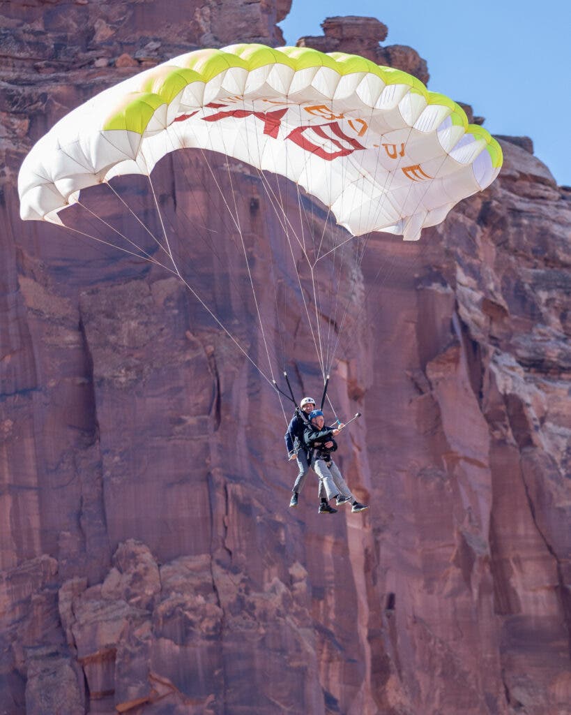 base jumpers hanging from a parachute