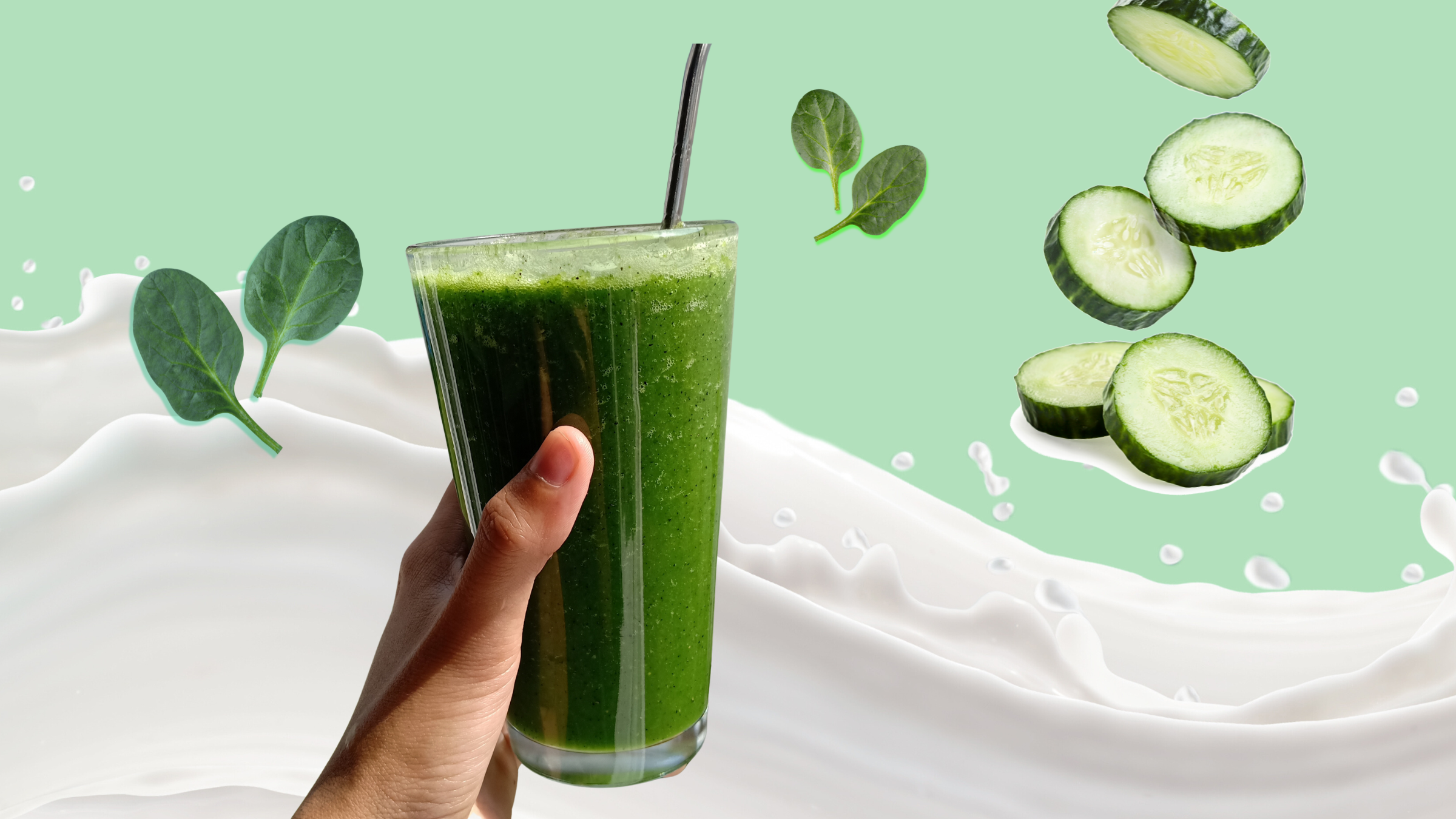An image of a person holding a green smoothie; there are cucumber slices and spinach leaves and milk in the background; vegan, protein-free smoothie