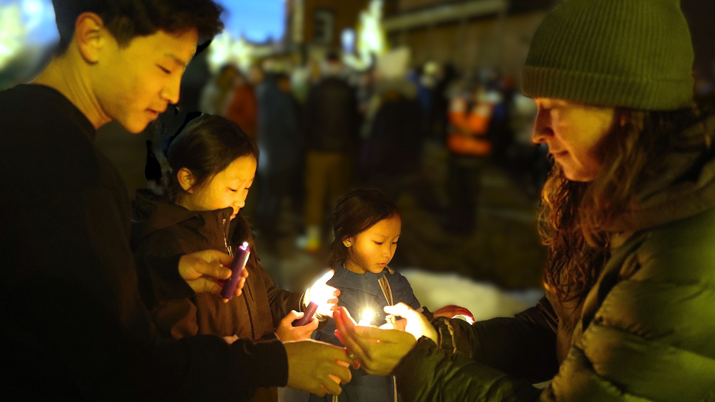 Sondrea Lyon lights candles for Logan (9), Riley (12), and Ethan (17) Oh in downtown Truckee (right to left)
