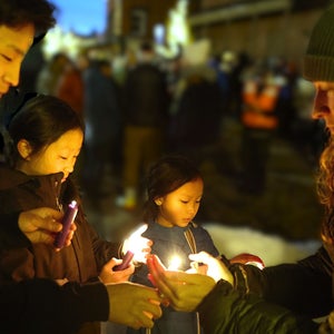 Sondrea Lyon lights candles for Logan (9), Riley (12), and Ethan (17) Oh in downtown Truckee (right to left)