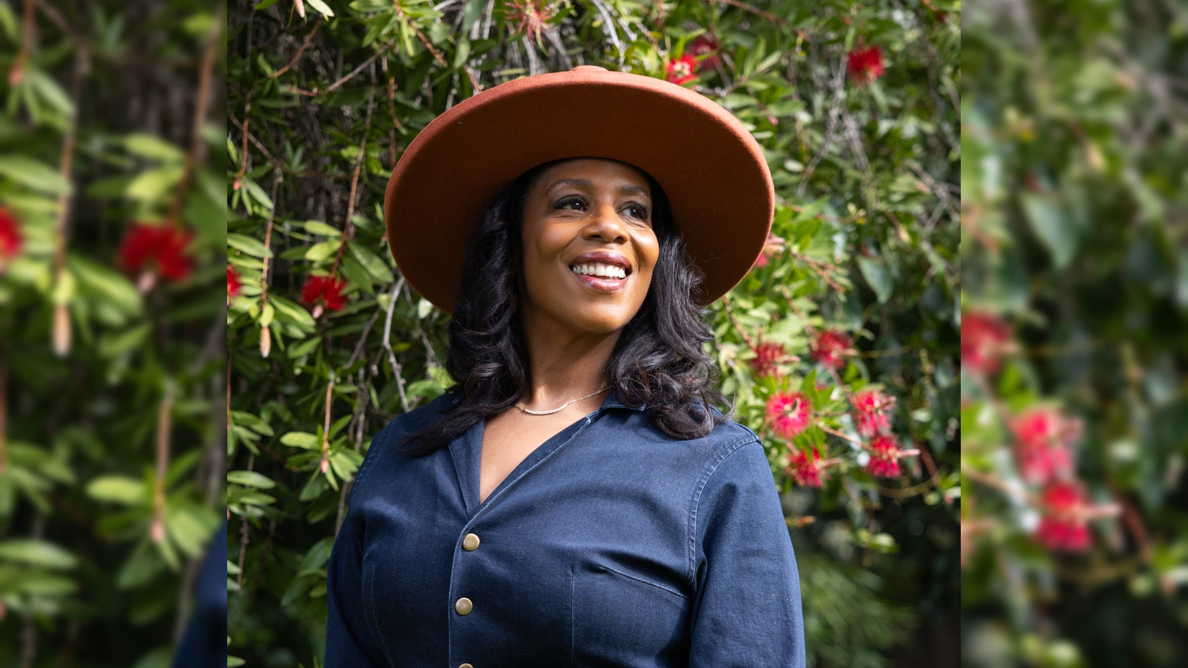 Rue Mapp portrait in front of a flowering bush.