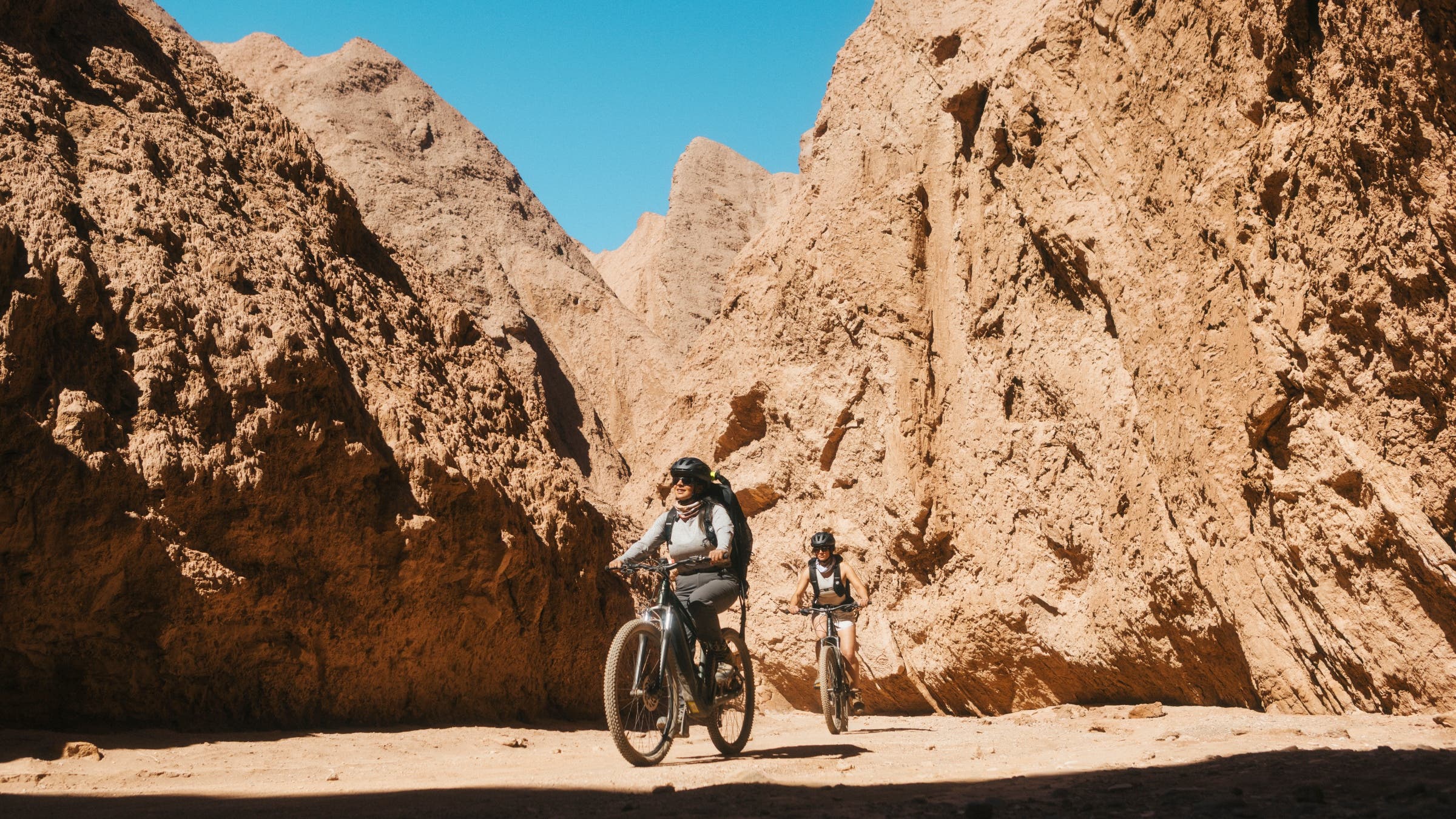 Mountain bikers in a red rock canyon.