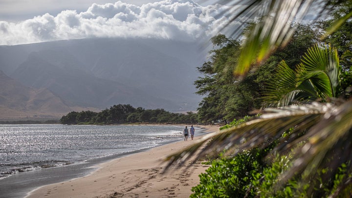 Two people walking on Sugar Beach in Kihei, Maui, Hawaii.