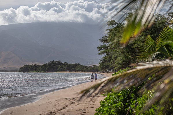 Two people walking on Sugar Beach in Kihei, Maui, Hawaii.
