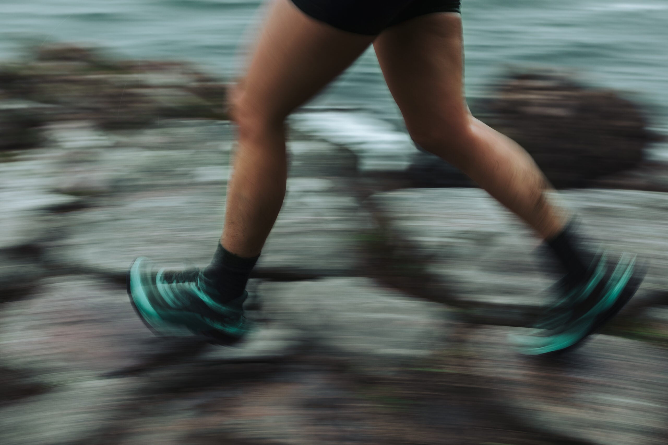 Close-up of a runner's legs running a trail race in bad weather.