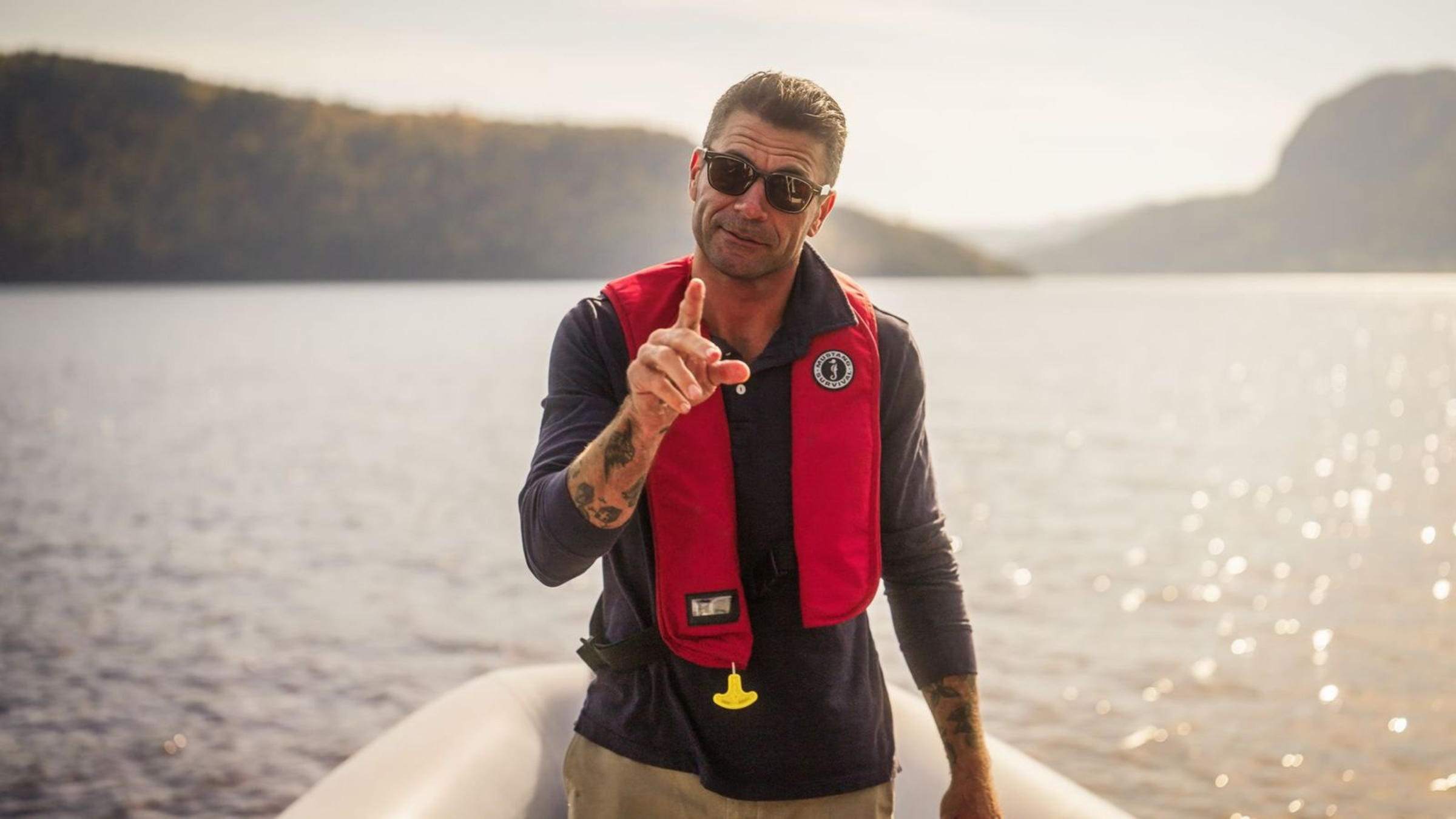 Josh Rosen, voditelj DIRT-a, na brodu nosi crveni prsluk za spašavanje sa sunčanom vodom iza sebe