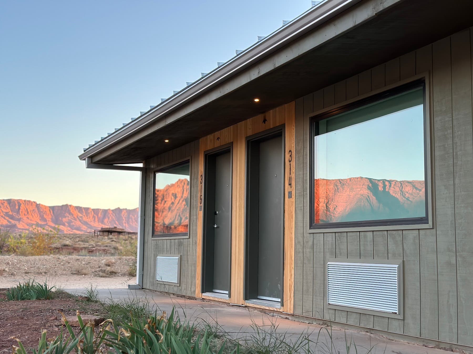 exterior of marble canyon lodge room with red cliffs reflected in the windows