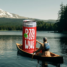 man canoes out across lake with an illustration of a large can of wine in the boat with him with mount hood in the background