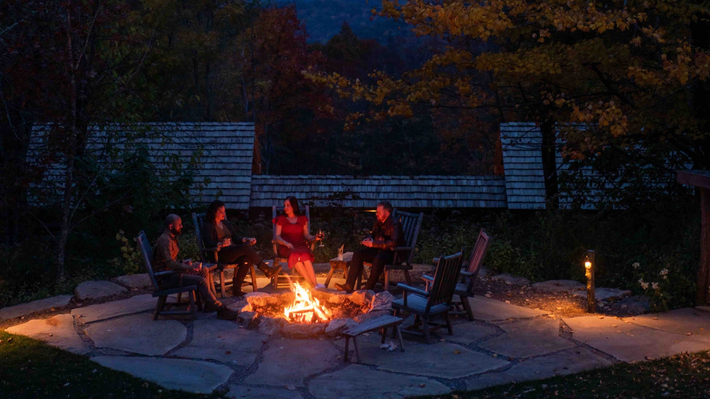 People sit around a fire on a landing at night.