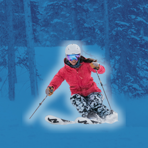 A skier in a red jacket and patterned pants carves through fresh snow, set against a blue-tinted forest background
