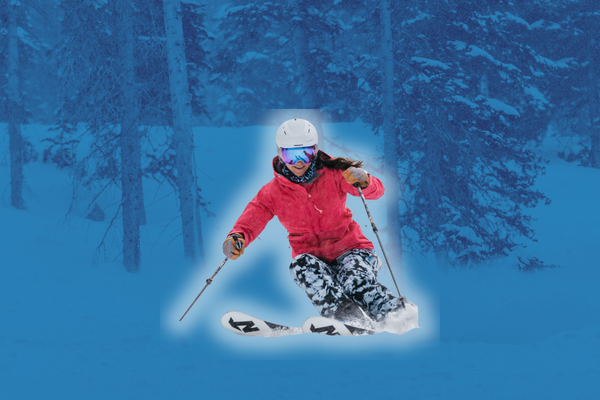 A skier in a red jacket and patterned pants carves through fresh snow, set against a blue-tinted forest background