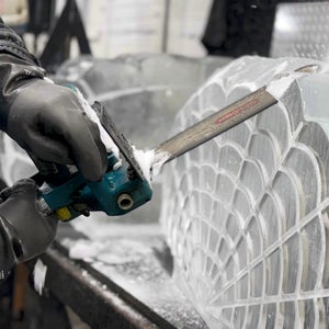 Max Barajas, the owner of Nadeau’s Ice Sculptures, carves a shell