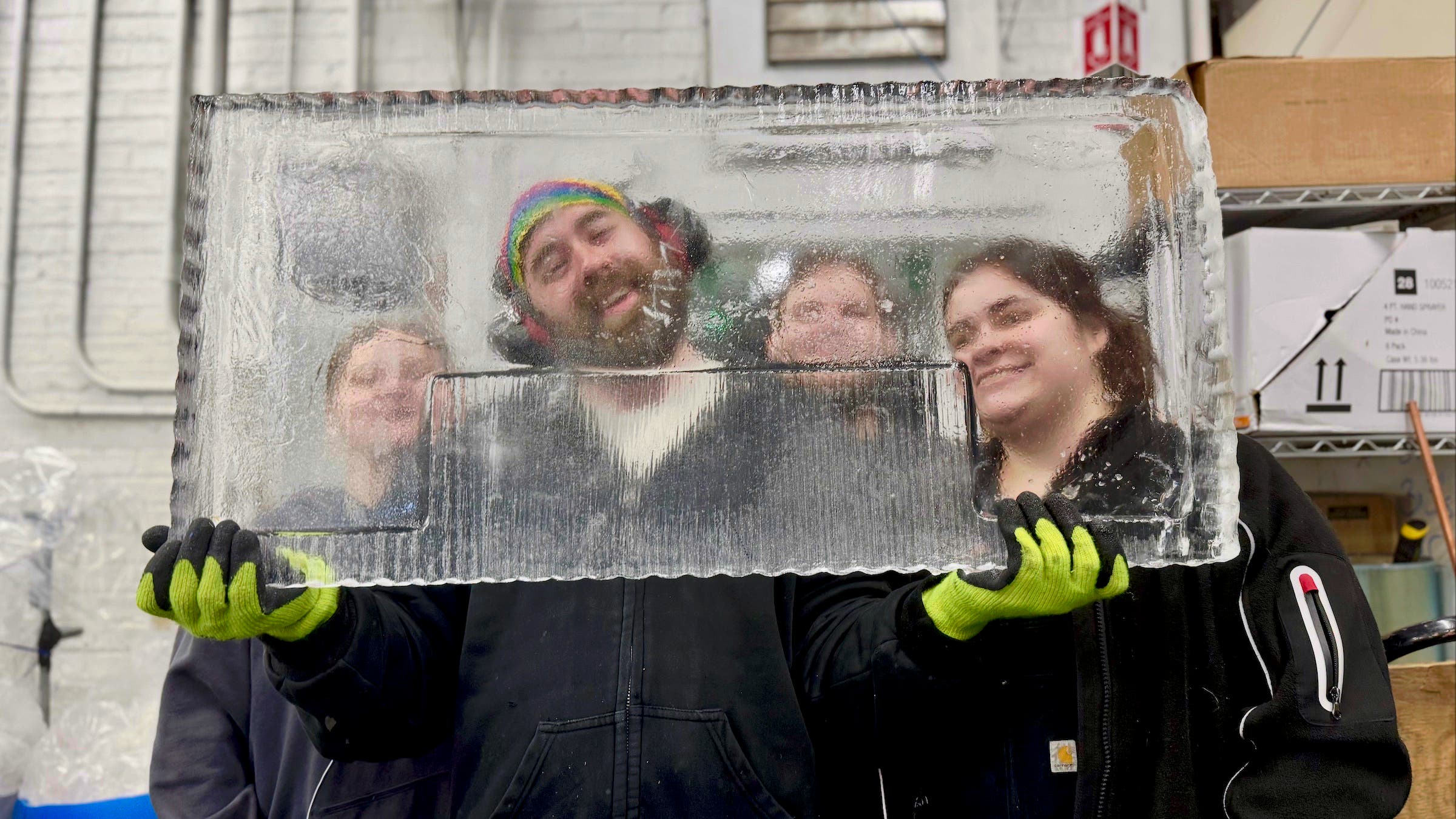 Staff pose for a portrait with a block of uncarved ice.