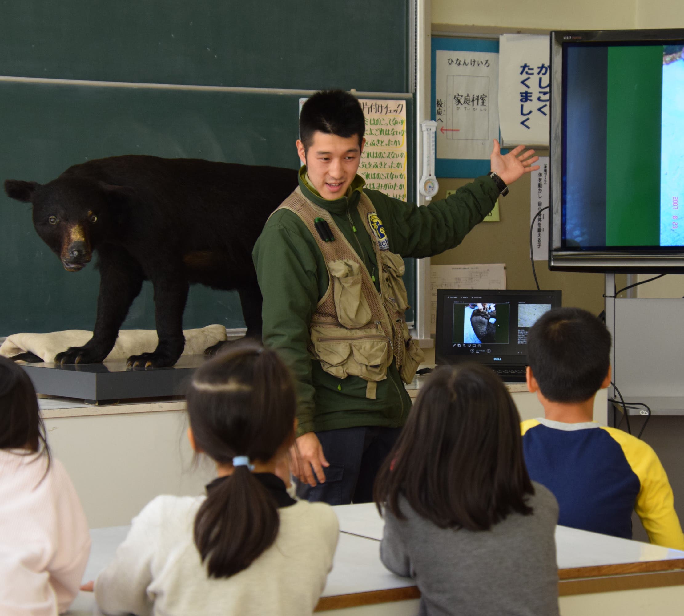 An instructor with Picchio talks to schoolchildren about bears