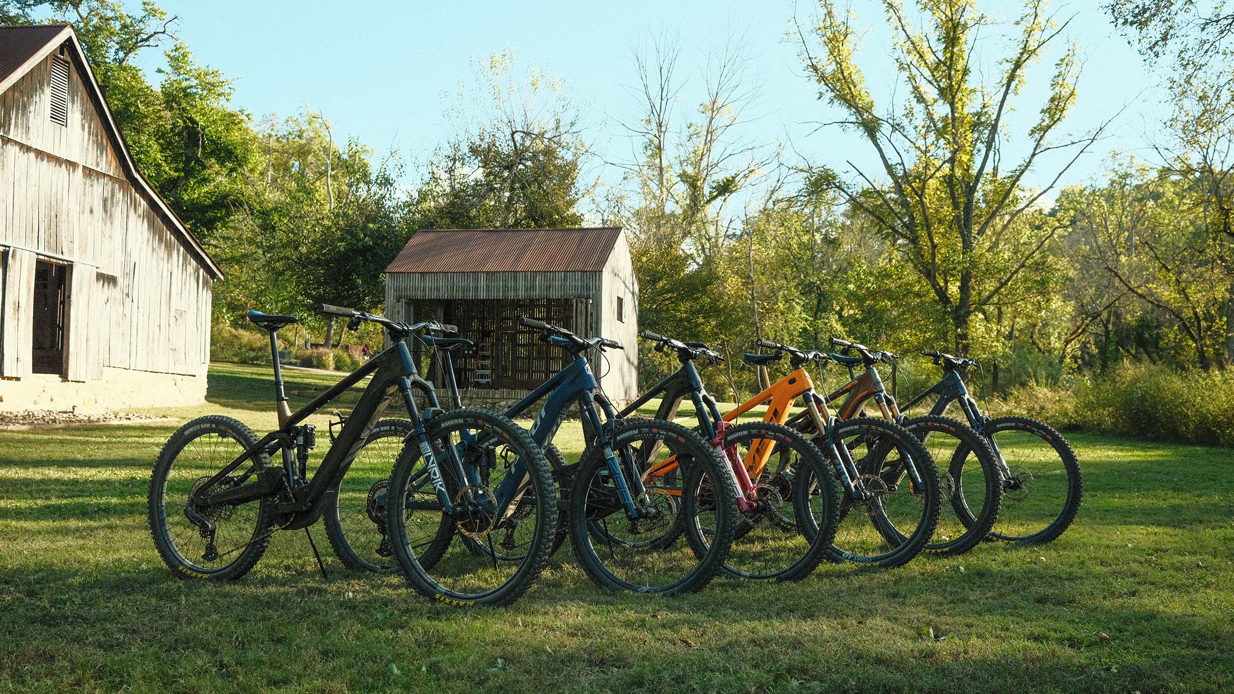 Best electric mountain bikes of 2026 lined up in grassy field during Pinkbike field test