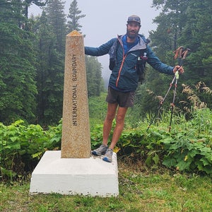 A hiker leans on a monument