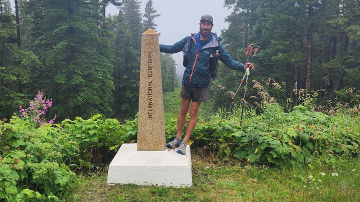 A hiker leans on a monument
