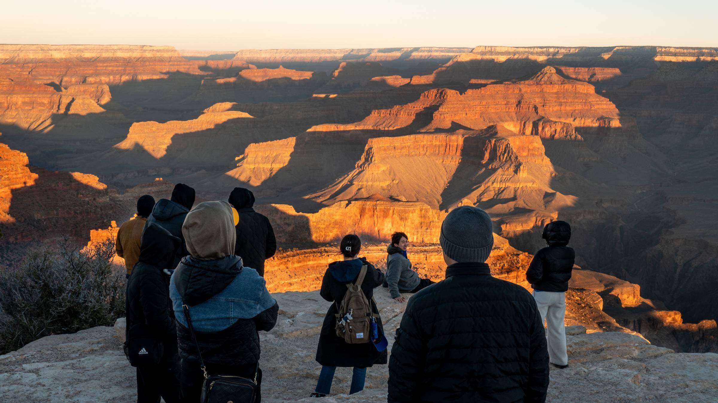 Tourists overlook the Grand Canyon at sunrise