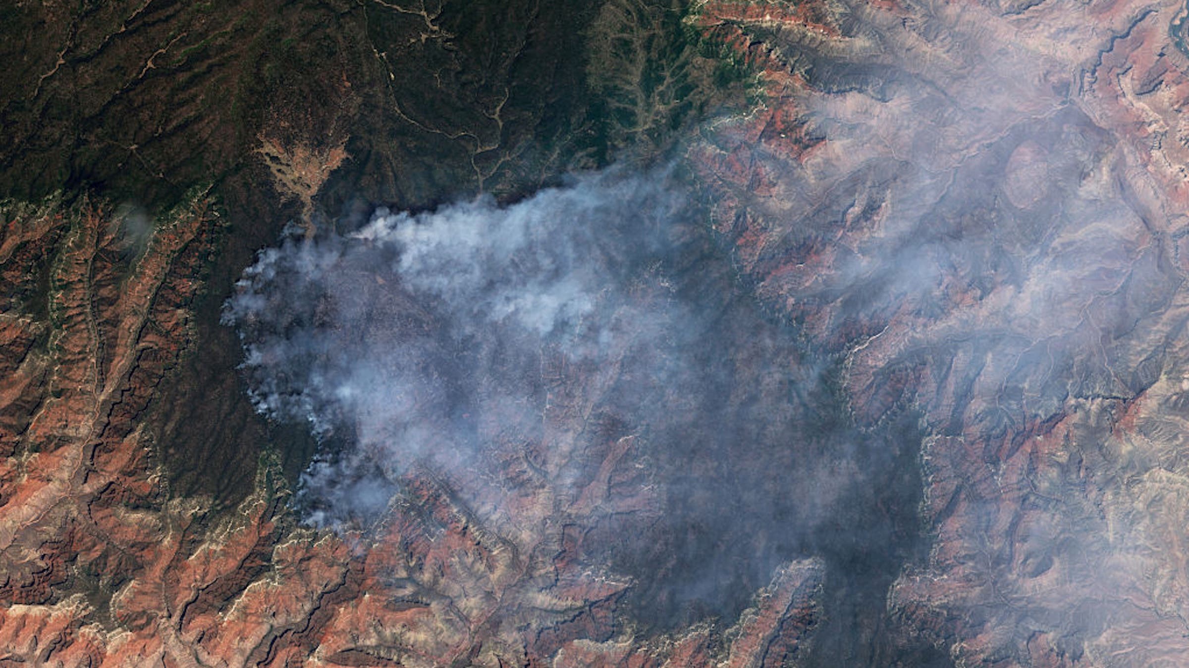 : A satellite view reveals thick smoke plumes driven by extreme heat, dry conditions, and gusty winds over the Grand Canyon