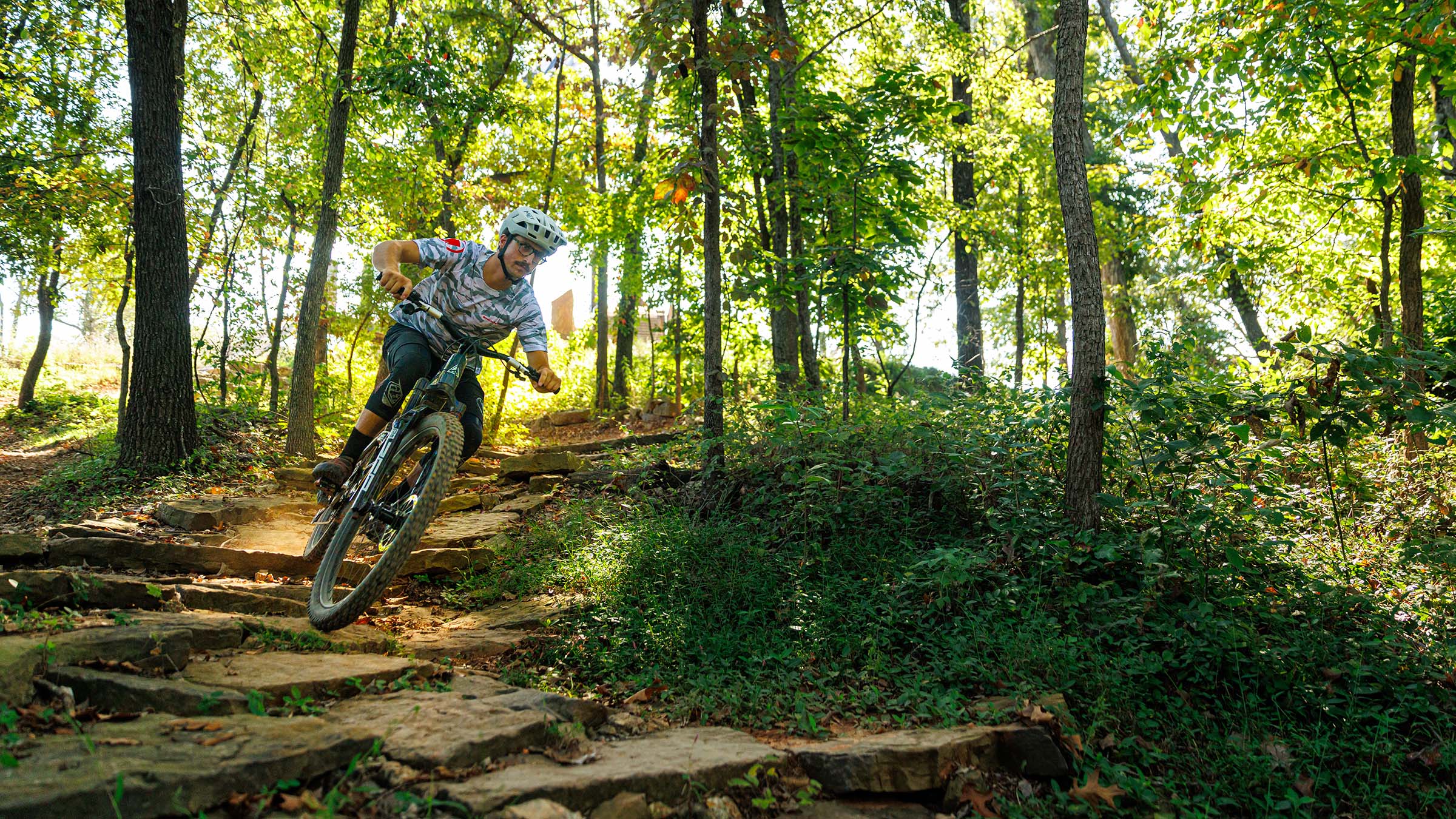 Mountain biker cornering on electric mountain bike on wooded trail