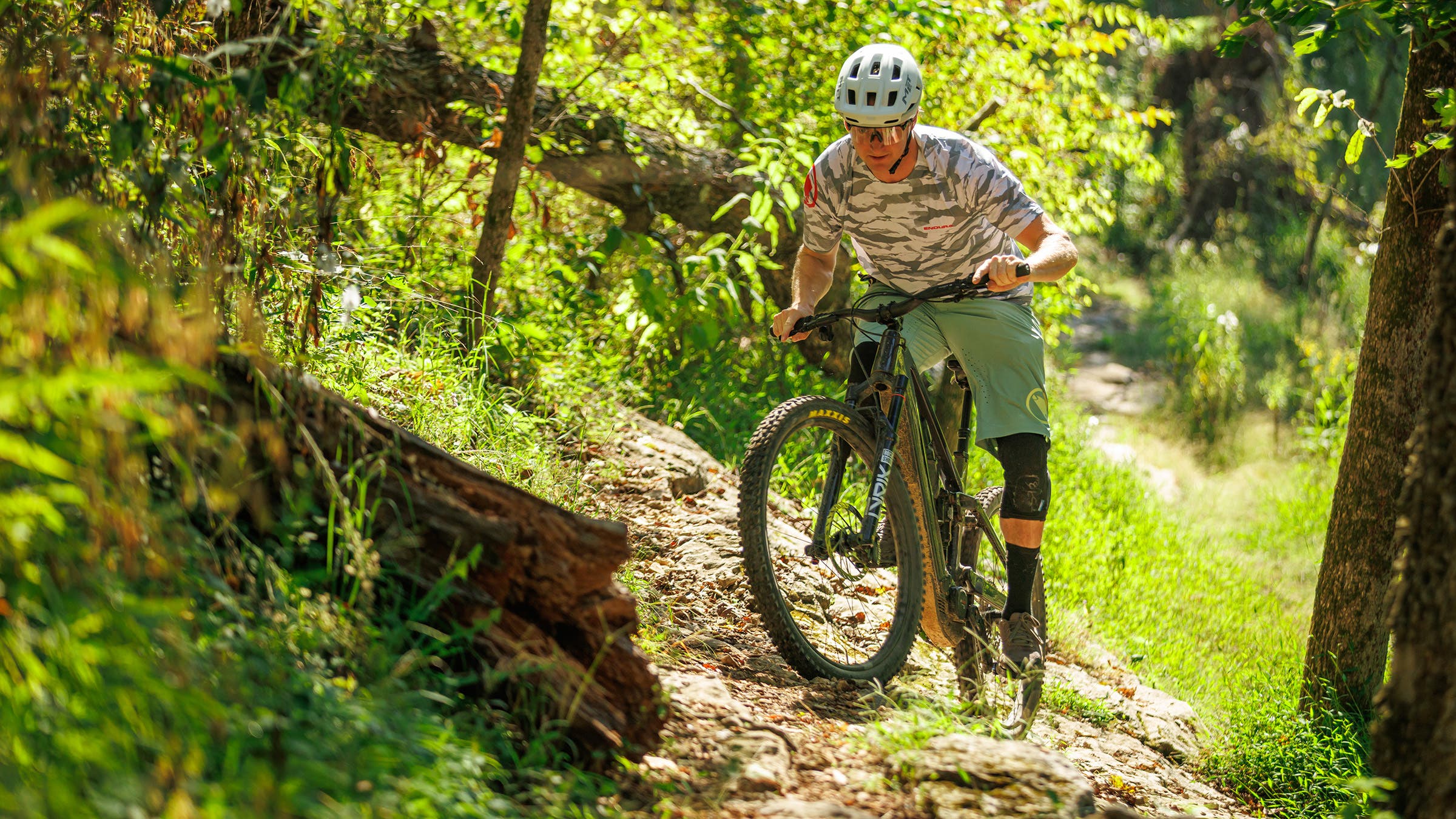 Mountain biker climbing up singletrack trail on Norco Sight VLT electric mountain bike