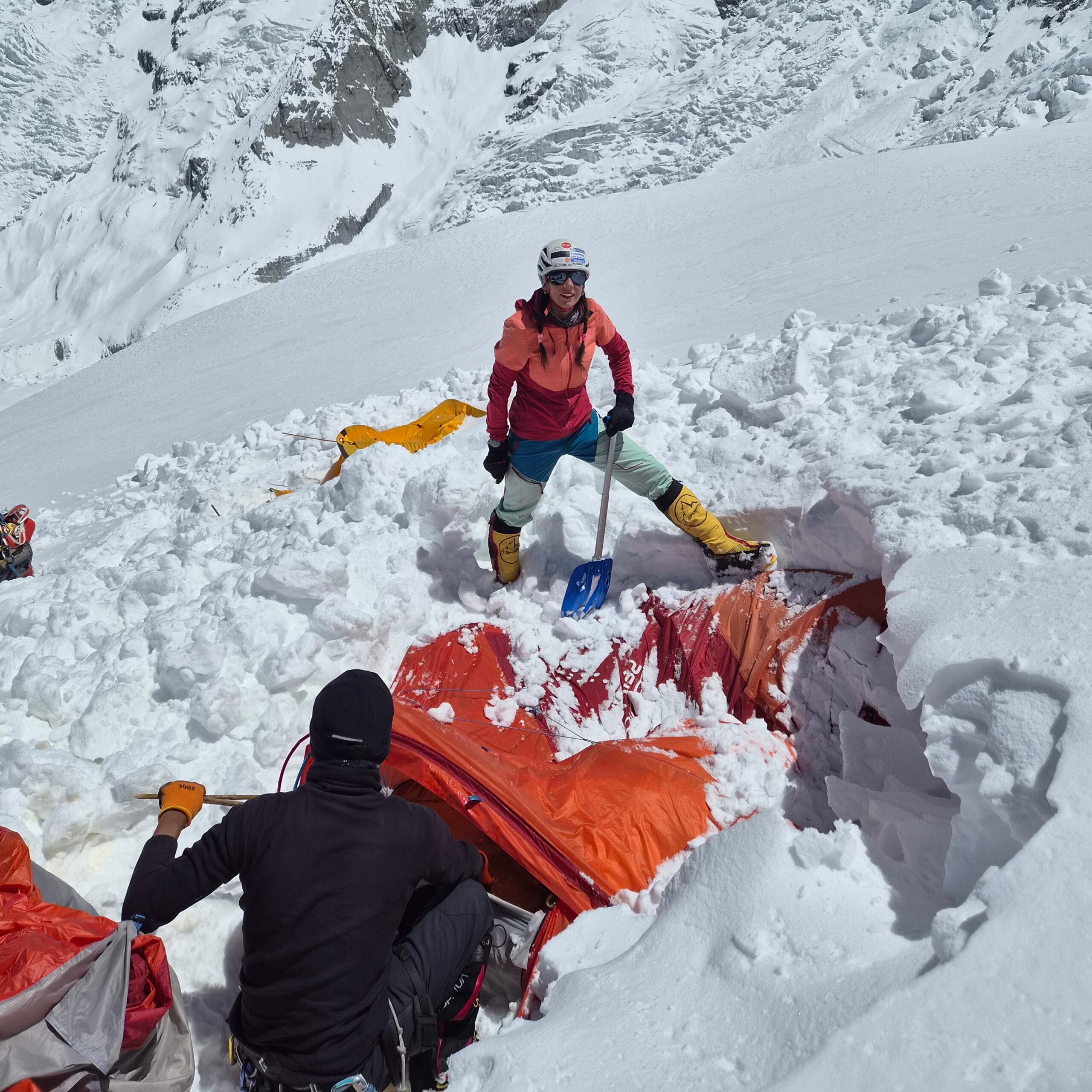 Stefi Troguet digs a tent out of deep snow