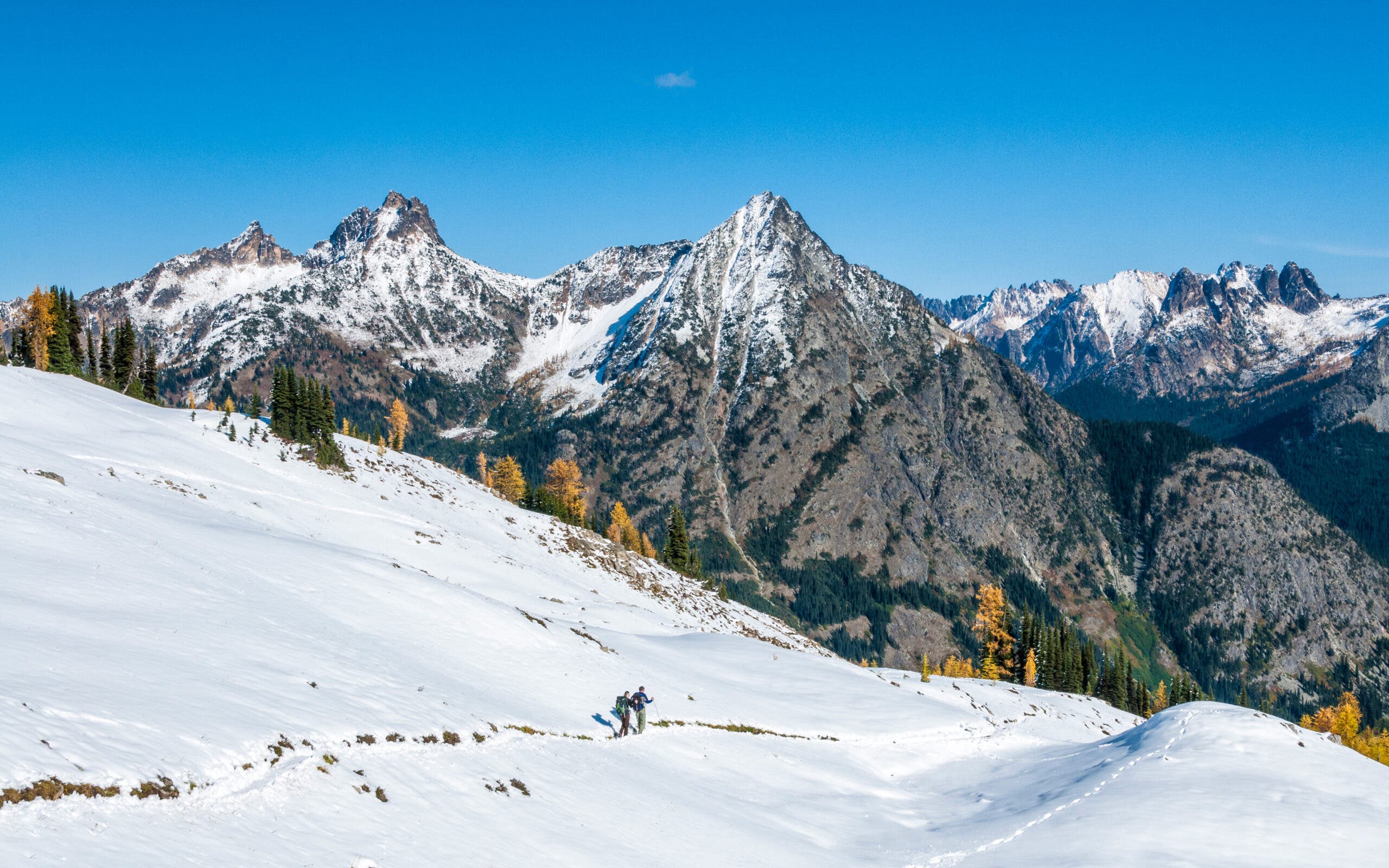 Hikers descend a snowy pass in Washington State