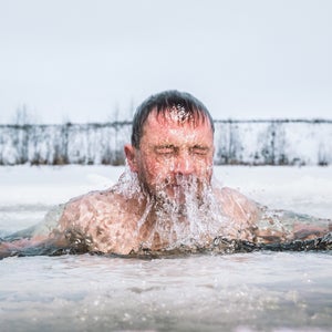 Man doing a cold plunge in an ice hole, coming up from under the water, doing a cold plunge mistake by plunging in too-cold of water