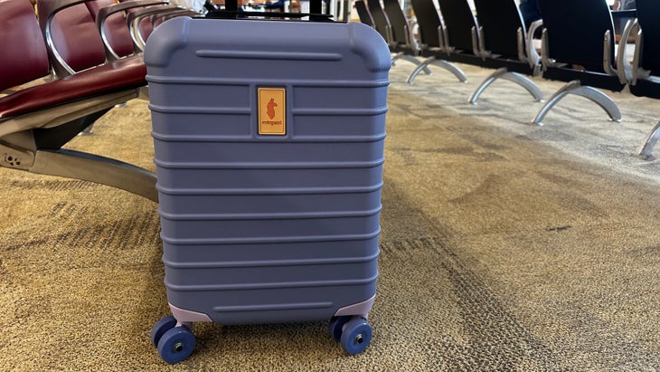 Cotopaxi hard-sided carry on suitcase has big wheels that roll smoothly through airport and over sidewalk cracks.