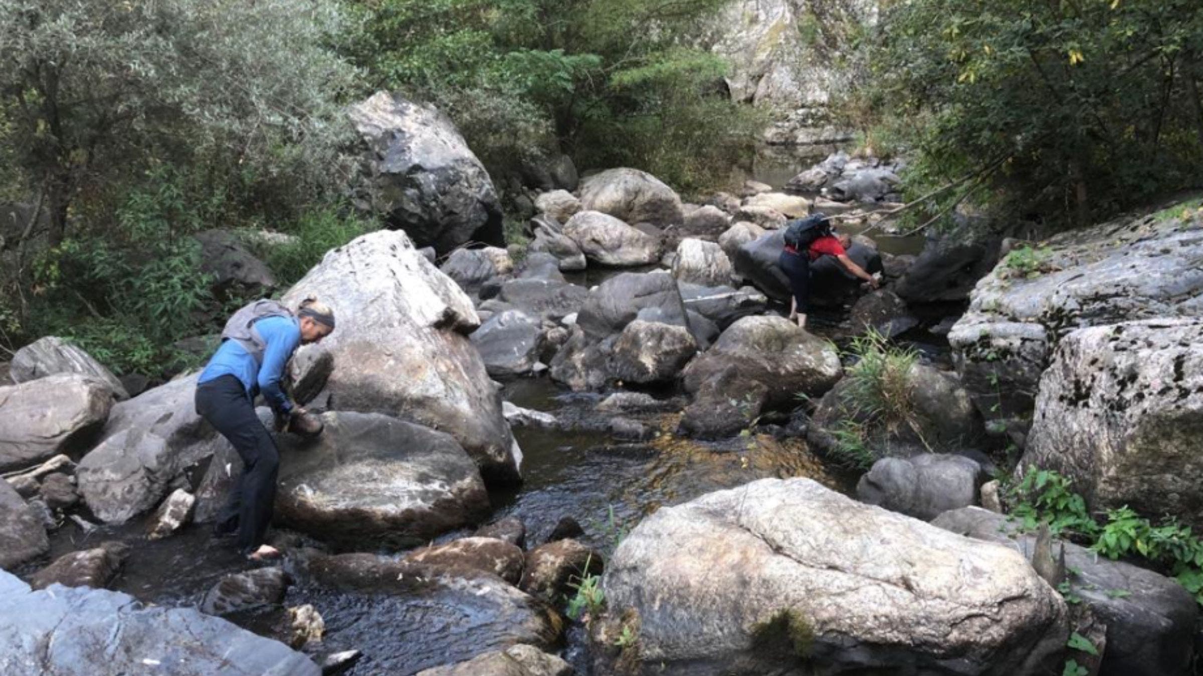two people crossing river