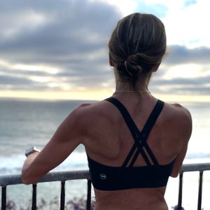 Runner standing at ocean overlook during running sports bra testing for Outside Magazine