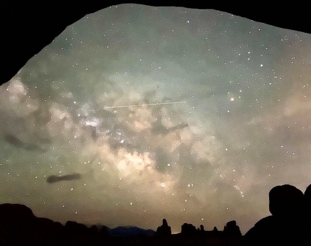 galaxy seen through an arch at night