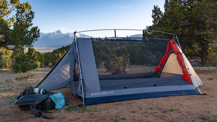 the tent set up with mountains in the background